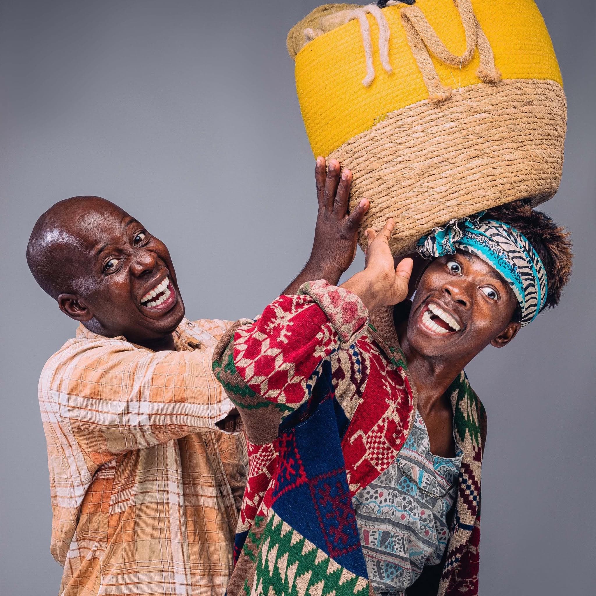 Gogo and Slwane balancing a woven basket in a studio portrait